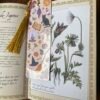 Marque-page cottagecore Practical Magic posé sur un livre